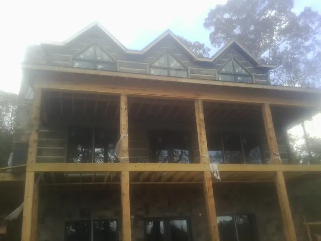Dormers and porch framing on a large log home under construction — Roof Coating work by our crew in Jim Thorpe