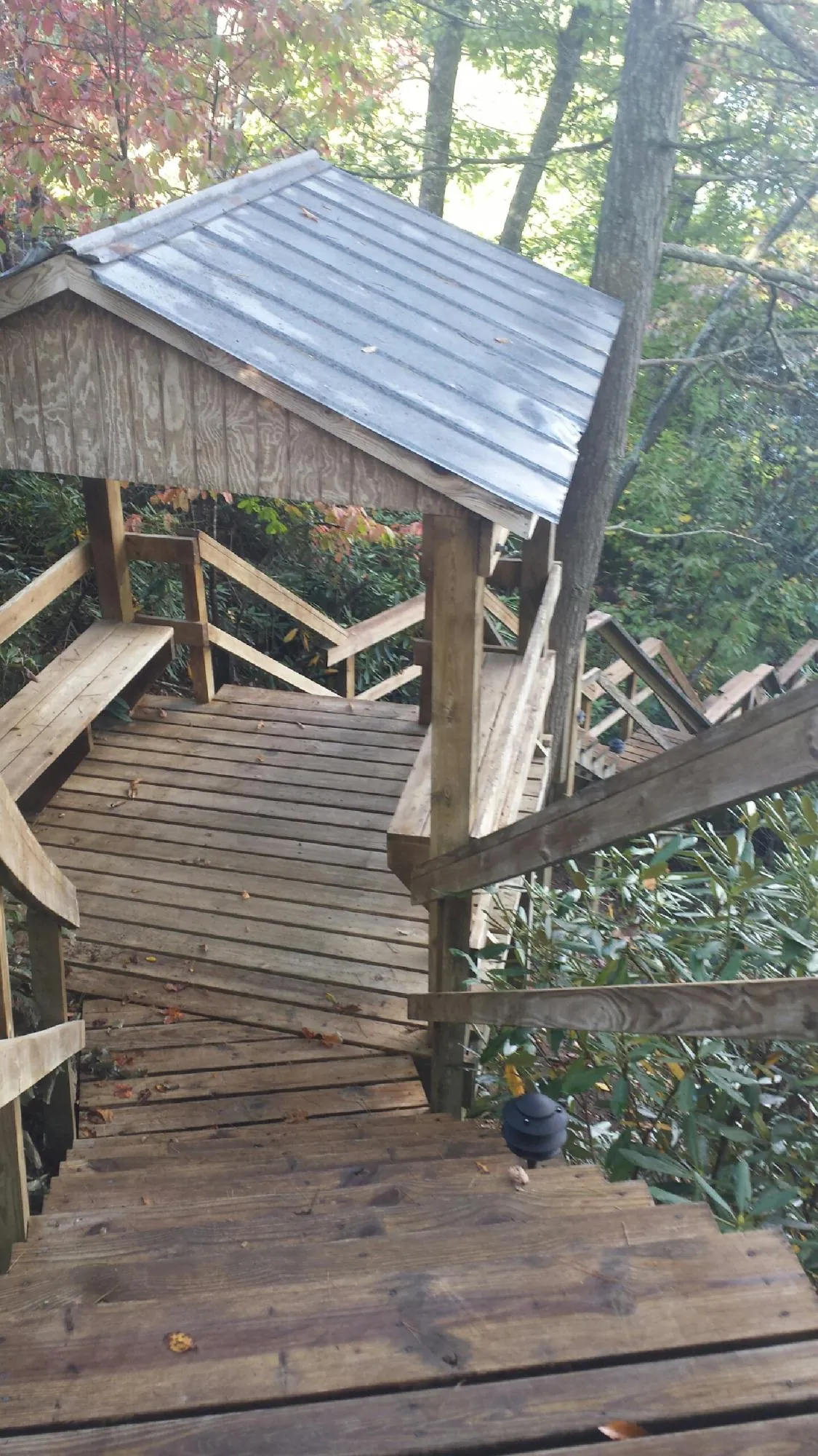 Metal roofed shelter over wooden steps on a wooded walkway — Skylight Repair & Installation work by our crew in Jim Thorpe